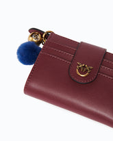 Portefeuille multifonction en cuir avec pompon - | Pinko